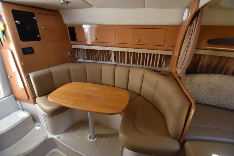 Slide: The Image of 2006 Chaparral Signature 290 interior with curved seating and wooden table. - 18