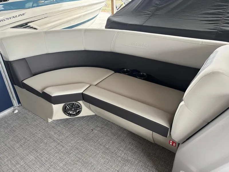 Slide: The Image of 2025 Harris Cruiser 210 SL boat interior with gray seating and speaker. - 5