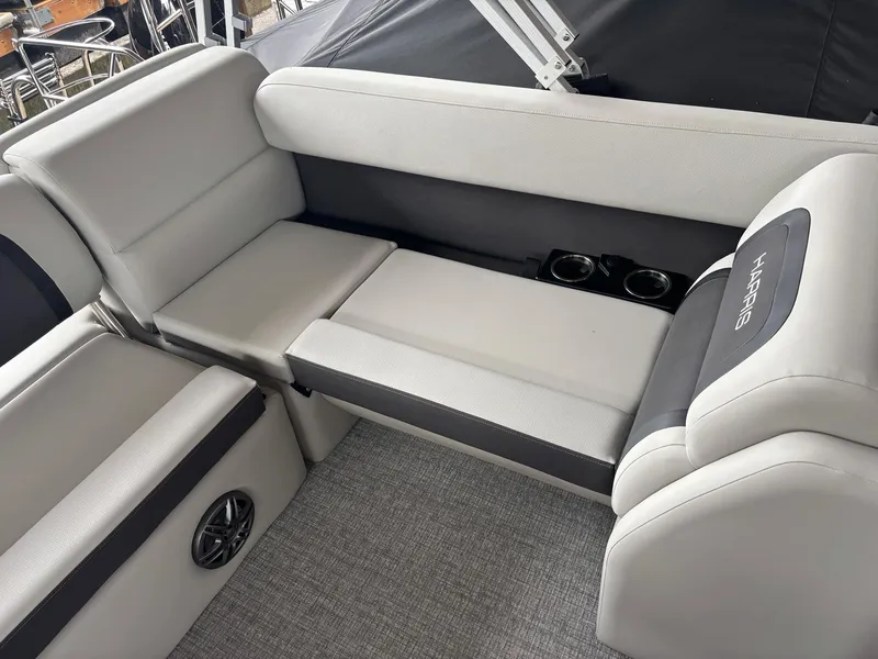 Slide: The Image of 2025 Harris Cruiser 210 SL interior seating with cup holders and speaker. - 9