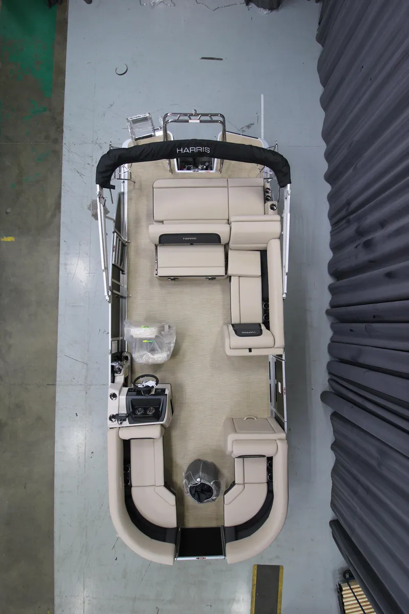 Slide: The Image of 2025 Harris Cruiser 210 SL pontoon boat, aerial view, beige seating, modern design. - 2