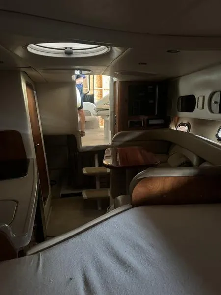 Slide: The Image of Interior of 2005 Four Winns 298 Vista boat, featuring cozy seating and wooden accents. - 22