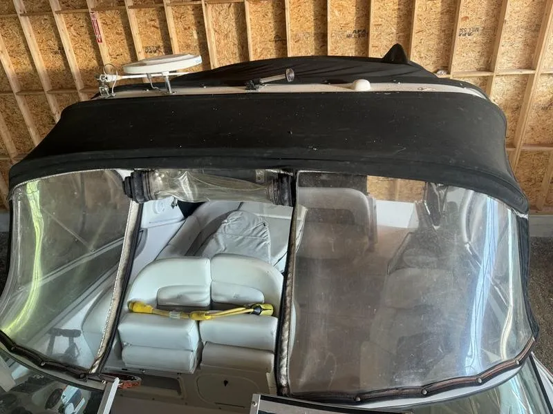 Slide: The Image of 2005 Four Winns 298 Vista boat with black canopy in a garage. - 28