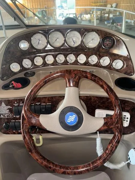 Slide: The Image of 2005 Four Winns 298 Vista dashboard with wood-grain steering wheel and instrument panel. - 31