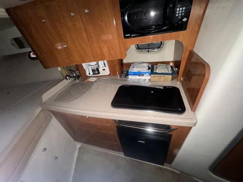 Slide: The Image of 2005 Four Winns 298 Vista boat kitchen with microwave, sink, and storage cabinets. - 36