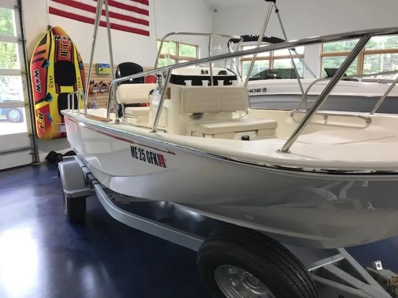 Slide: The Image of 2023 Boston Whaler 170 Montauk boat in showroom with American flag backdrop. - 12