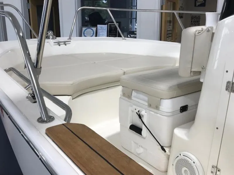 Slide: The Image of 2023 Boston Whaler 170 Montauk boat interior with cushioned seating and storage. - 4
