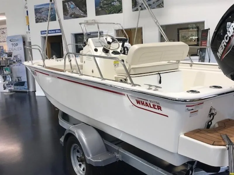 Slide: The Image of 2023 Boston Whaler 170 Montauk boat displayed indoors on a trailer. - 5