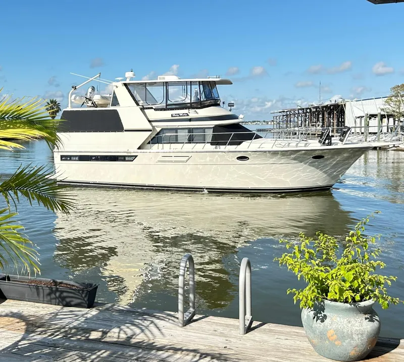 Slide: The Image of 1989 Carver Californian 48 yacht on calm water, sunny day, dockside view. - 10