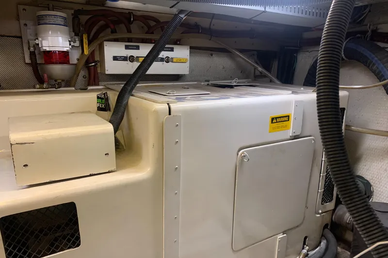 Slide: The Image of Engine room of 1989 Carver Californian 48 yacht, featuring mechanical equipment and wiring. - 28