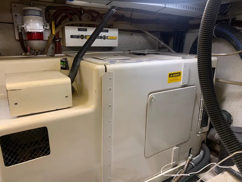 Slide: The Image of Engine room of 1989 Carver Californian 48 yacht, featuring mechanical equipment and wiring. - 38