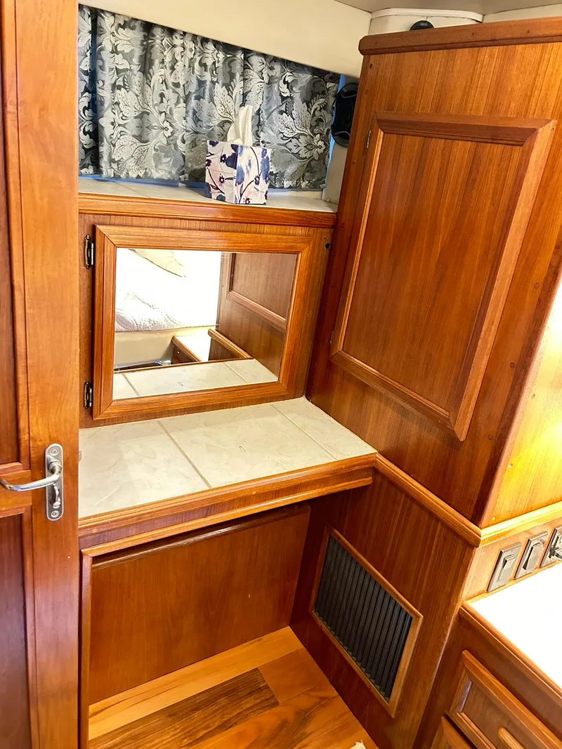 Slide: The Image of 1989 Carver Californian 48 yacht interior with wooden cabinetry and mirror. - 49