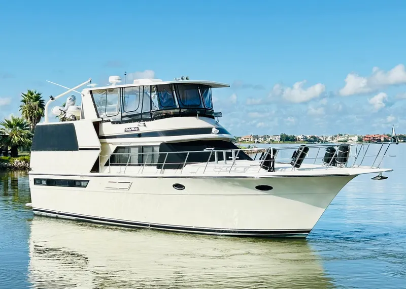 Slide: The Image of 1989 Carver Californian 48 yacht cruising on a sunny day, with clear skies and calm waters. - 9