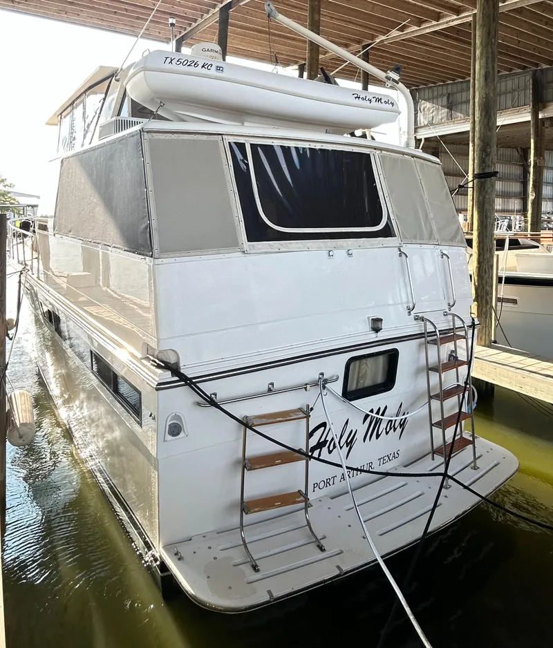 Slide: The Image of 1989 Carver Californian 48 yacht docked, rear view, with ladder and canopy. - 13