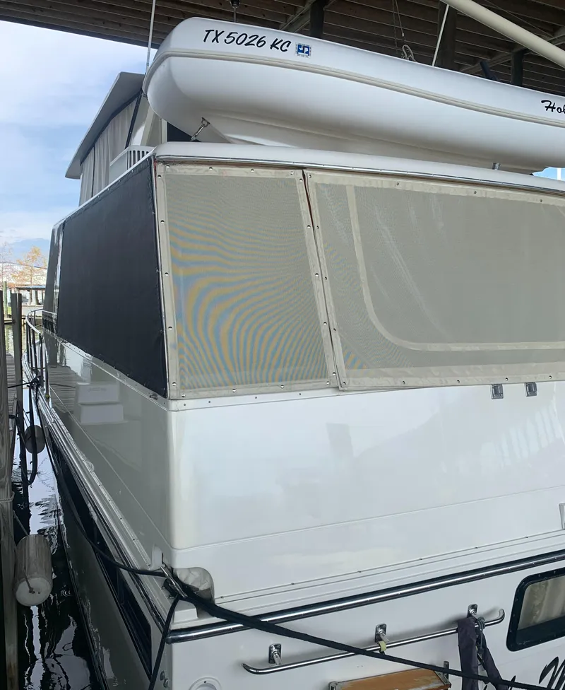 Slide: The Image of 1989 Carver Californian 48 yacht docked with covered deck and visible registration number. - 17