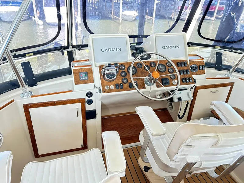 Slide: The Image of 1989 Carver Californian 48 yacht helm with Garmin navigation, wood accents, and white seating. - 2