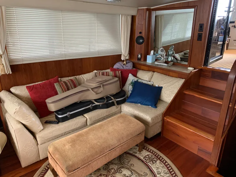 Slide: The Image of 1989 Carver Californian 48 yacht interior with cozy seating, guitar cases, and wooden accents. - 20