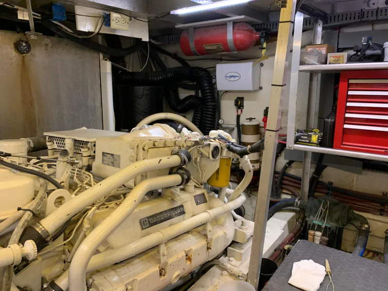 Slide: The Image of Engine room of 1989 Carver Californian 48 yacht with visible machinery and tools. - 36