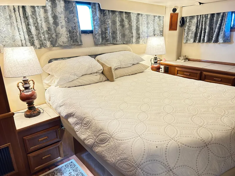 Slide: The Image of Luxurious bedroom interior of 1989 Carver Californian 48 yacht with elegant bedding and lamps. - 42