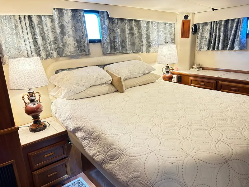 Slide: The Image of Cozy bedroom in 1989 Carver Californian 48 yacht with elegant bedding and lamps. - 43