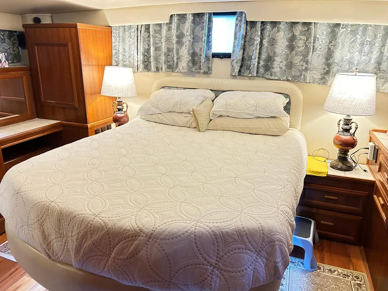Slide: The Image of Cozy bedroom in 1989 Carver Californian 48 yacht with elegant bedding and wooden furnishings. - 45