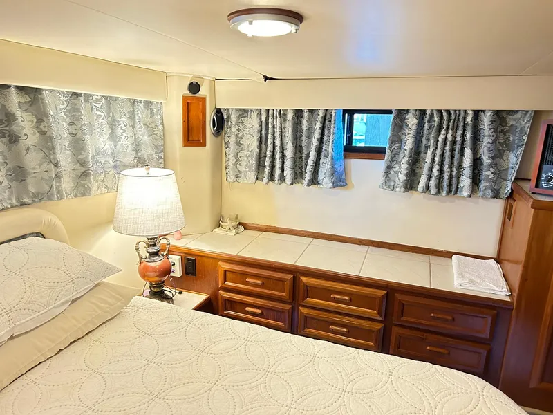 Slide: The Image of Cozy bedroom in 1989 Carver Californian 48 yacht with elegant wood cabinetry and soft lighting. - 47