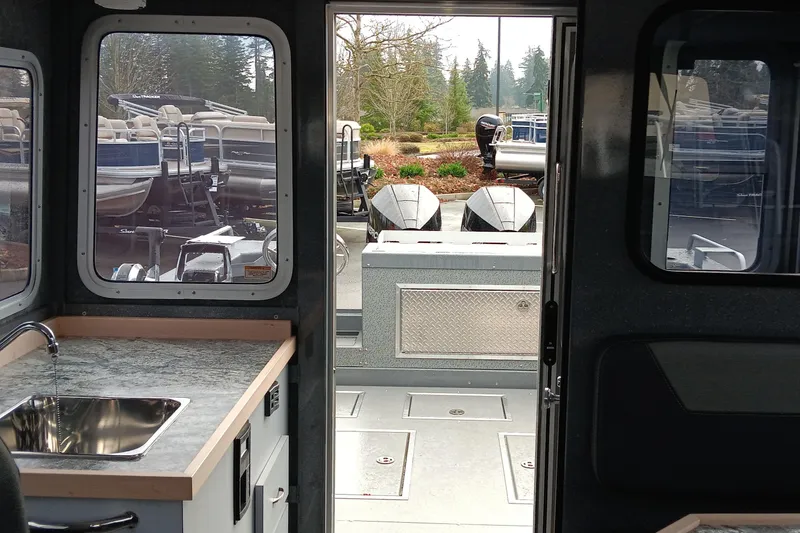 Slide: The Image of Interior view of 2025 Spartan 2800 Olympia boat, featuring a kitchenette and outdoor deck. - 13