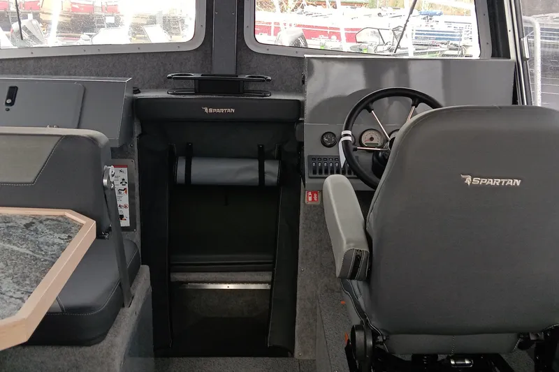 Slide: The Image of Interior of 2025 Spartan 2800 Olympia boat, featuring steering wheel and seating. - 14