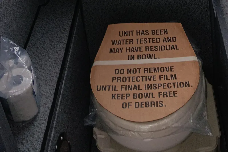 Slide: The Image of Toilet with protective film in Spartan 2800 Olympia, 2025 model, includes water testing notice. - 6