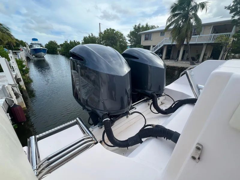 Slide: The Image of 2011 Grady-White Canyon 306 boat with dual outboard motors docked by a canal. - 4