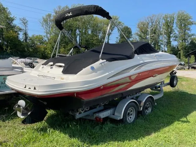 Slide: The Image of 2002 Sea Ray 220 Bow Rider boat on trailer, covered, parked on grass. - 1