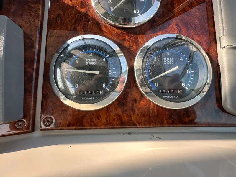 Slide: The Image of 2004 Formula 34 PC boat dashboard with gauges and controls, docked at marina. - 12