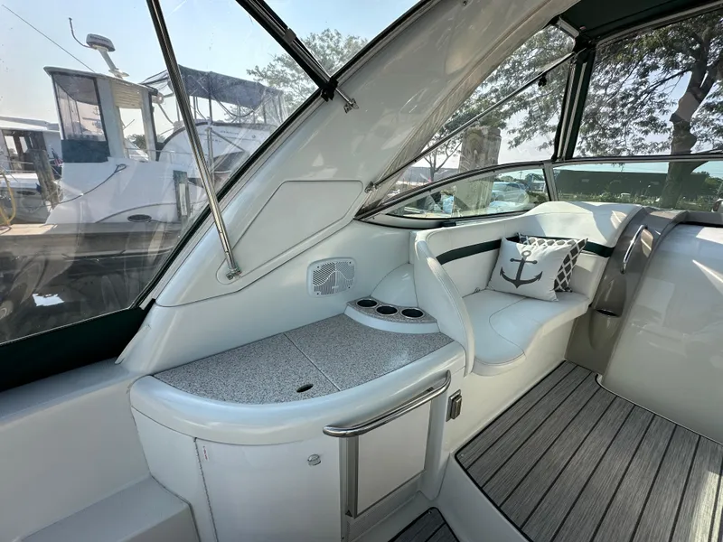 Slide: The Image of 2004 Formula 34 PC yacht interior with white seating and table, docked by a marina. - 5