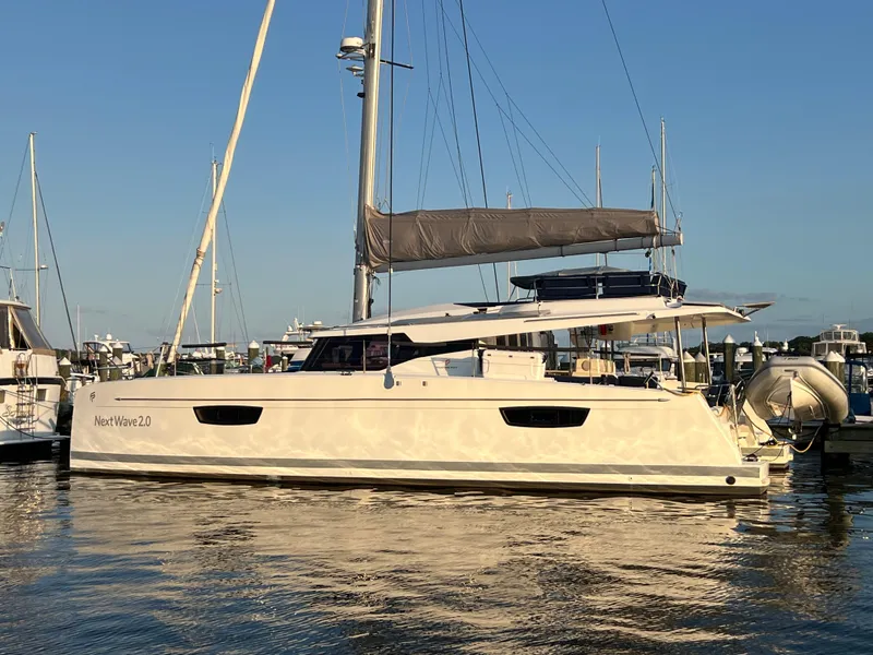 Slide: The Image of 2020 Fountaine Pajot Elba 45 catamaran docked in a marina, under clear blue skies. - 21