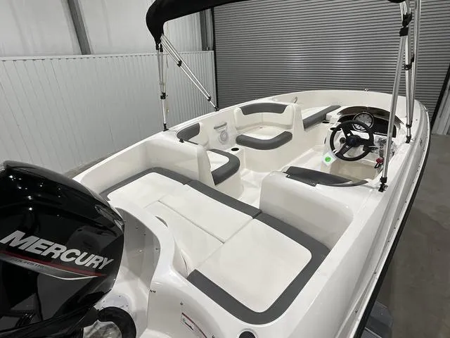 Slide: The Image of 2025 Bayliner Element E16 boat interior with Mercury engine, white seating, and steering console. - 9