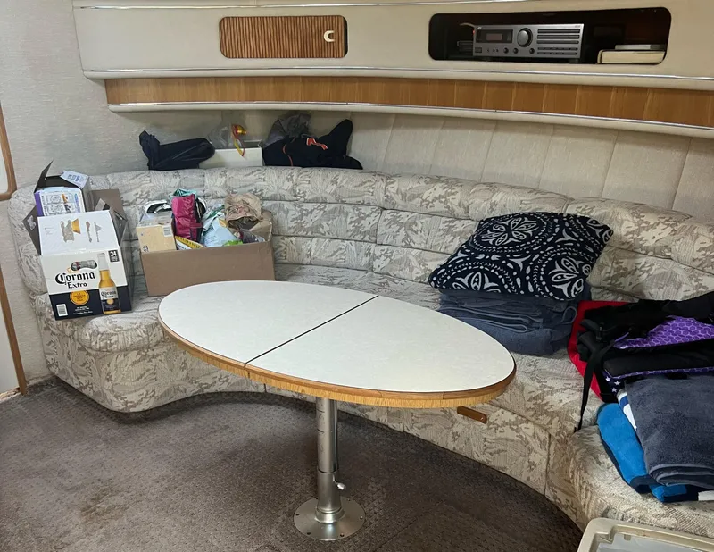 Slide: The Image of Interior of 1990 Sea Ray 420 Sundancer with cozy seating and table. - 13