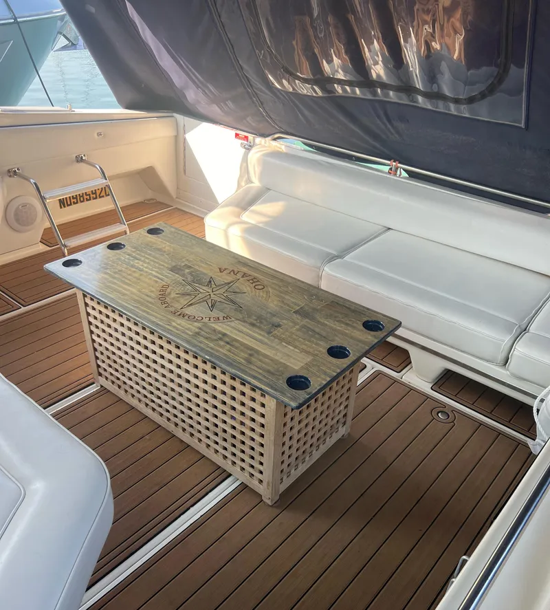 Slide: The Image of 1990 Sea Ray 420 Sundancer interior with wooden table and white seating. - 15