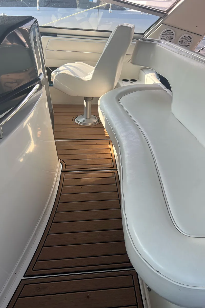 Slide: The Image of 1990 Sea Ray 420 Sundancer interior with white seating and wooden flooring. - 18