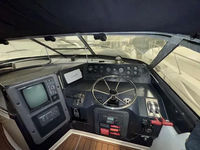 Slide: The Image of Cockpit of 1990 Sea Ray 420 Sundancer with steering wheel and navigation equipment. - 19