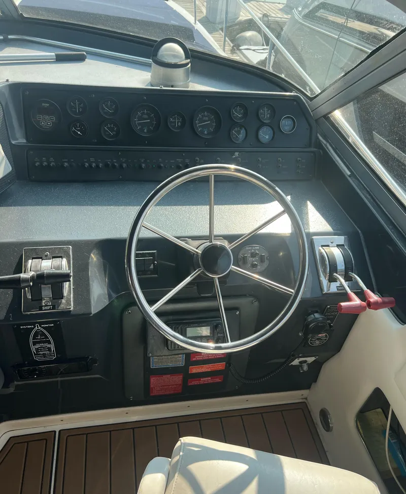 Slide: The Image of Steering wheel and dashboard of a 1990 Sea Ray 420 Sundancer boat. - 2