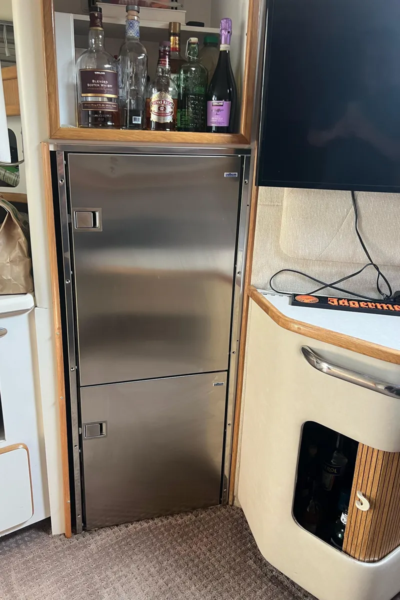 Slide: The Image of 1990 Sea Ray 420 Sundancer interior with stainless steel fridge and bar area. - 5