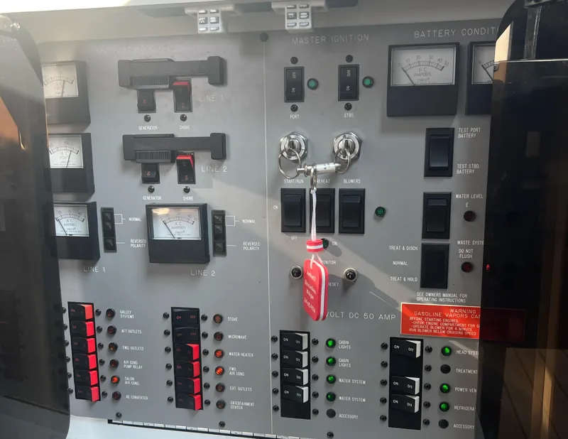 Slide: The Image of Control panel of a 1990 Sea Ray 420 Sundancer boat with switches and gauges. - 8