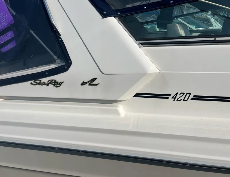 Slide: The Image of Close-up of 1990 Sea Ray 420 Sundancer boat exterior with logo and model number. - 9