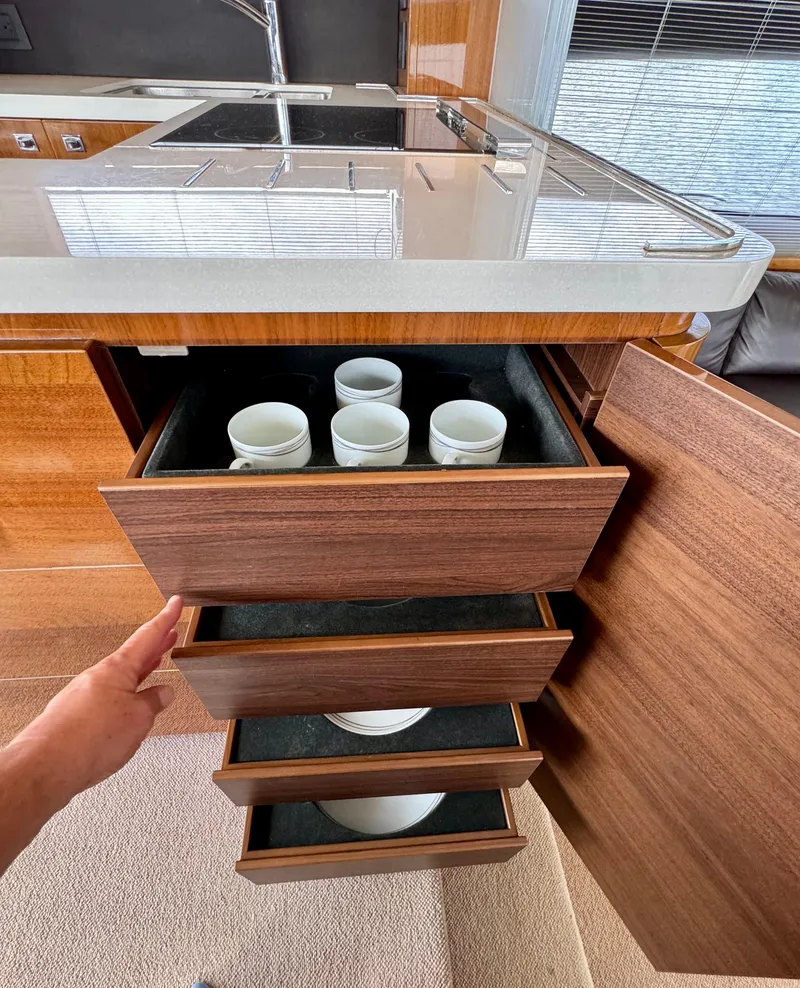 Slide: The Image of Wooden kitchen drawers with cups in a 2012 Princess Flybridge 60 Motor Yacht. - 26