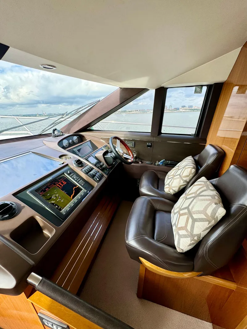 Slide: The Image of Luxurious helm of 2012 Princess Flybridge 60 Motor Yacht with leather seating and navigation controls. - 32