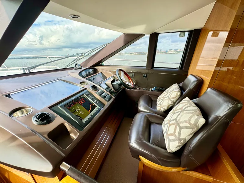 Slide: The Image of Luxurious helm of 2012 Princess Flybridge 60 Motor Yacht with leather seats and navigation controls. - 33