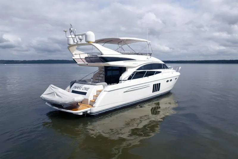 Slide: The Image of 2012 Princess Flybridge 60 Motor Yacht on calm water under cloudy sky. - 6