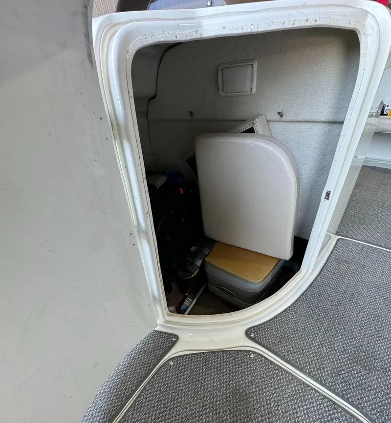 Slide: The Image of Storage compartment inside 2004 Glastron DX 215 boat, featuring seating and equipment. - 12