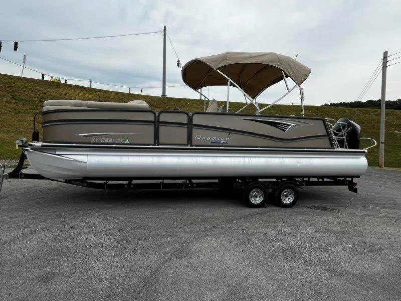 Slide: The Image of 2021 Premier 250 Grand Majestic pontoon boat on trailer, parked outdoors. - 16