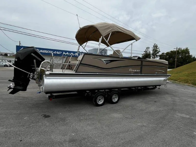Slide: The Image of 2021 Premier 250 Grand Majestic pontoon boat on trailer, featuring a canopy and sleek design. - 21