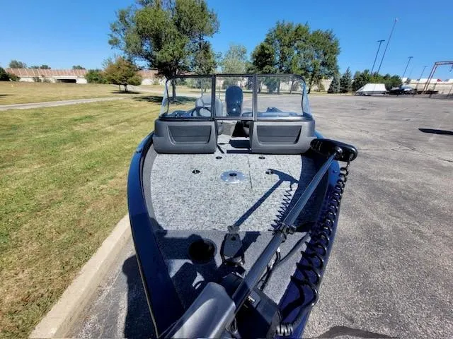 Slide: The Image of 2025 Tracker Pro Guide V-16 WT boat on pavement, surrounded by trees and grass. - 3